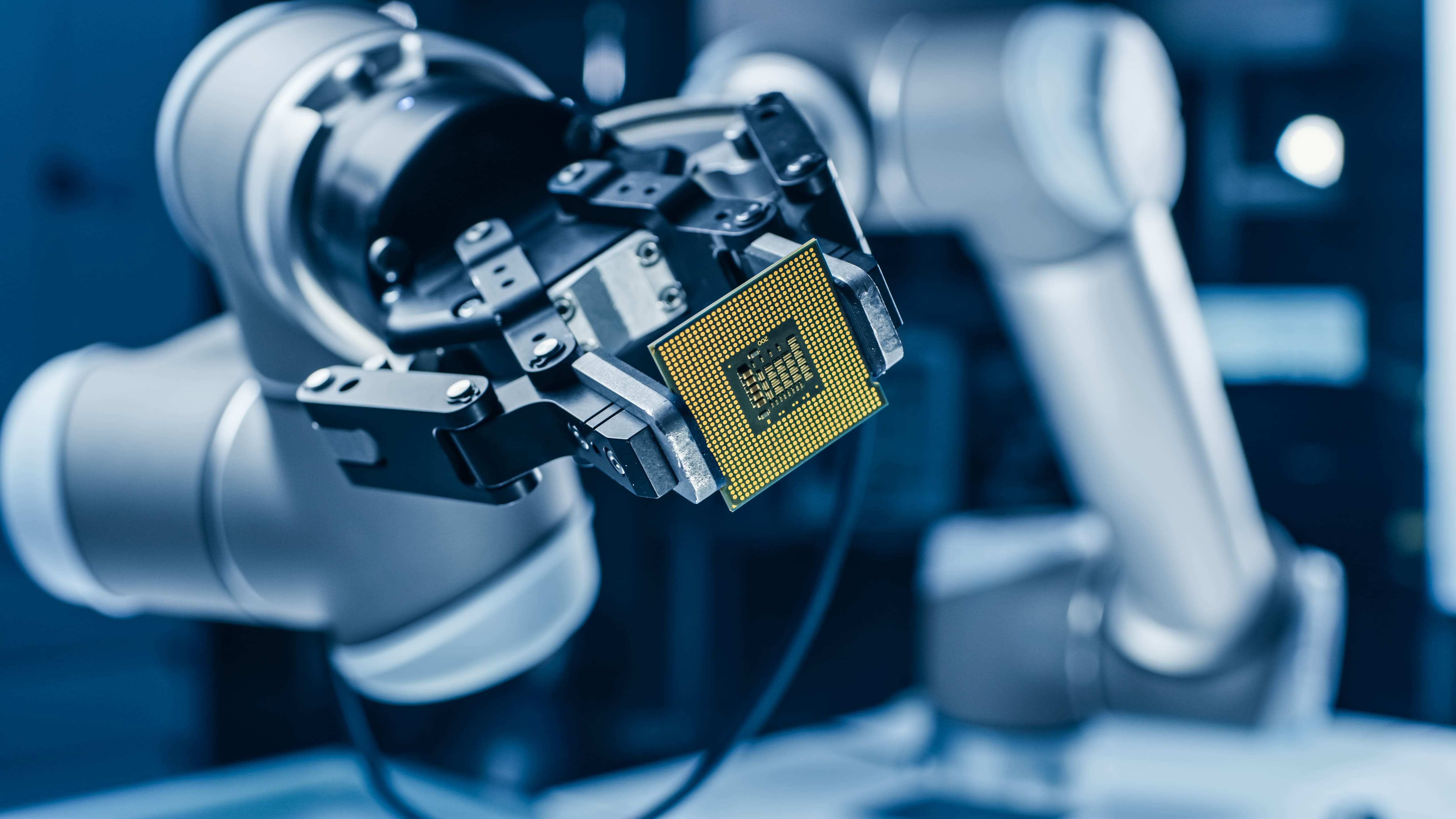 Robotic arm holding a semiconductor component.