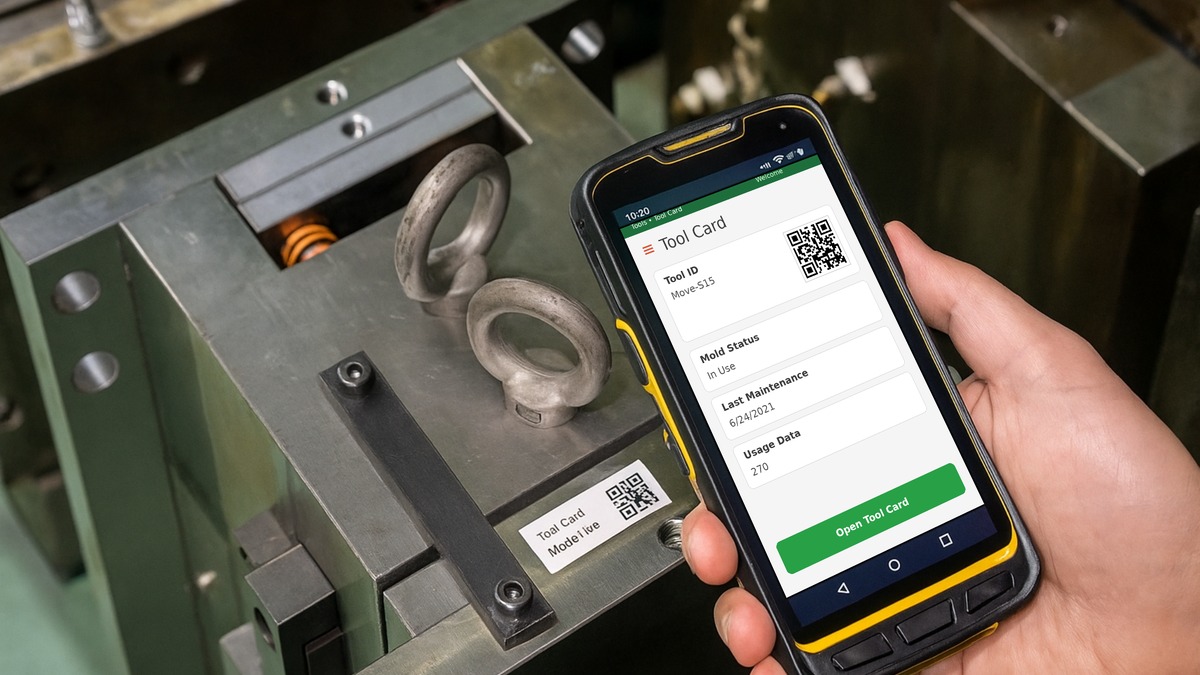 Worker scanning a QR-labelled industrial tool with a handheld device.