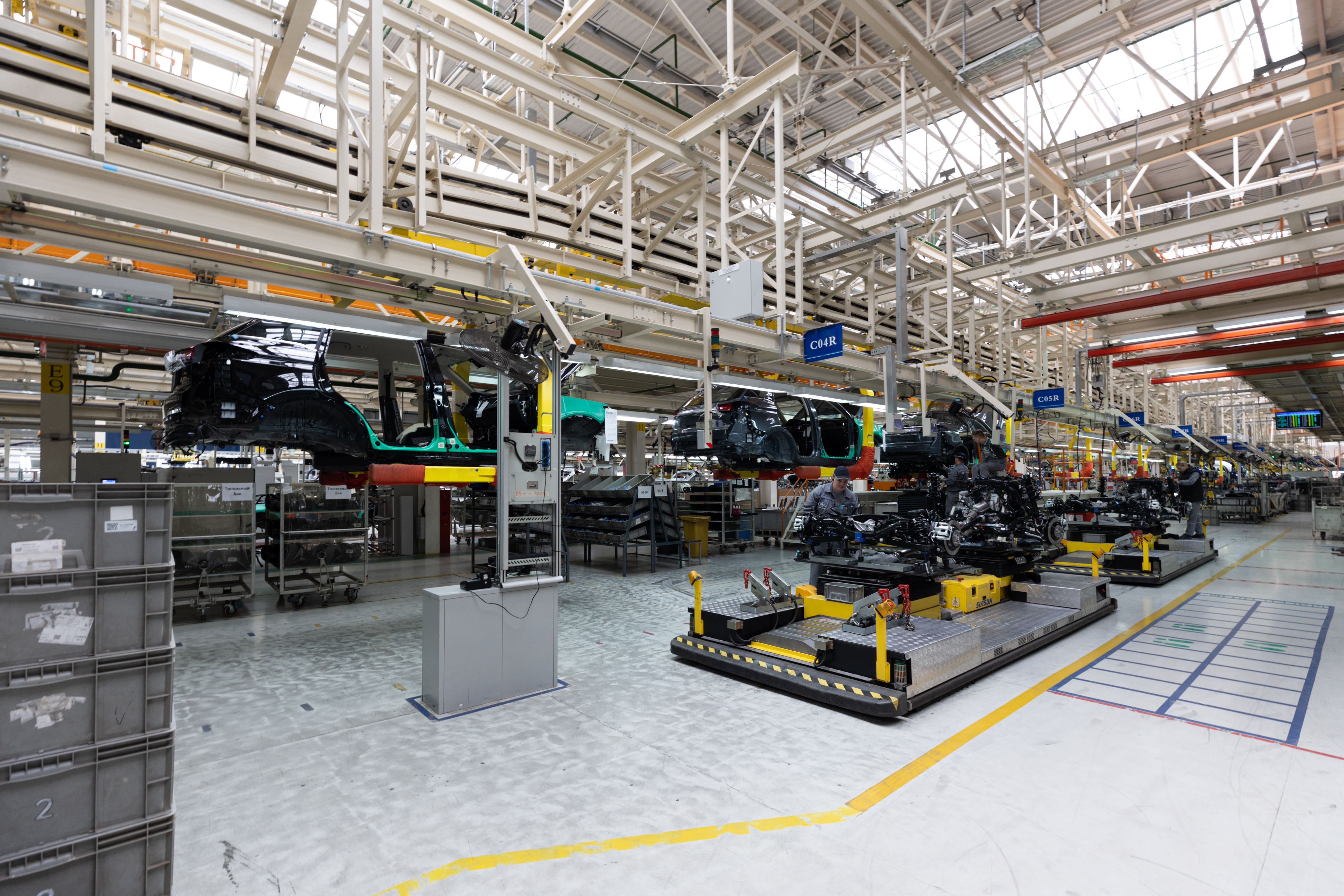 Automotive manufacturing line with vehicles and machinery.