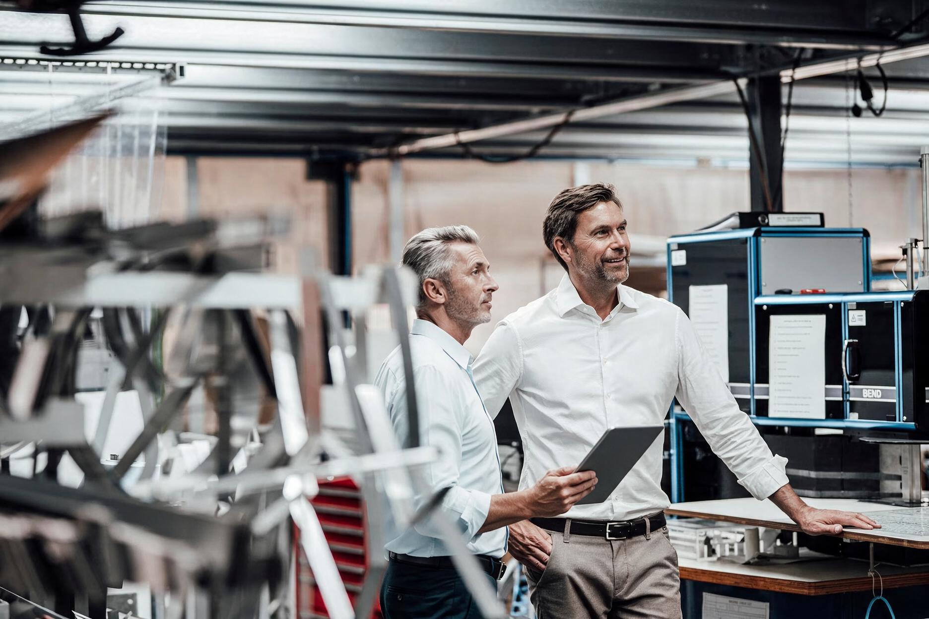 Project and operations leaders reviewing delivery progress on the factory floor.